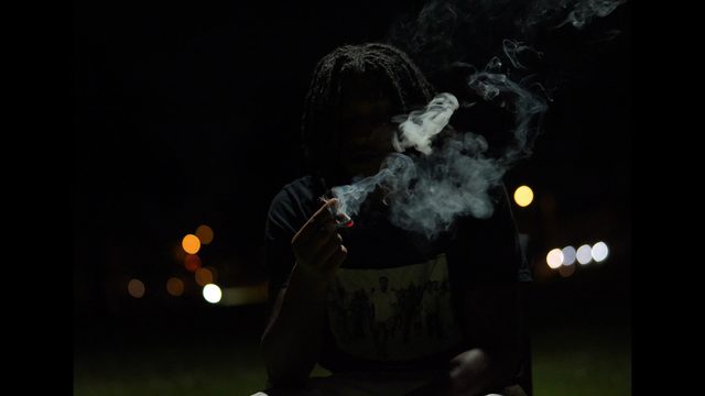 Night music video still with smoke and city lights